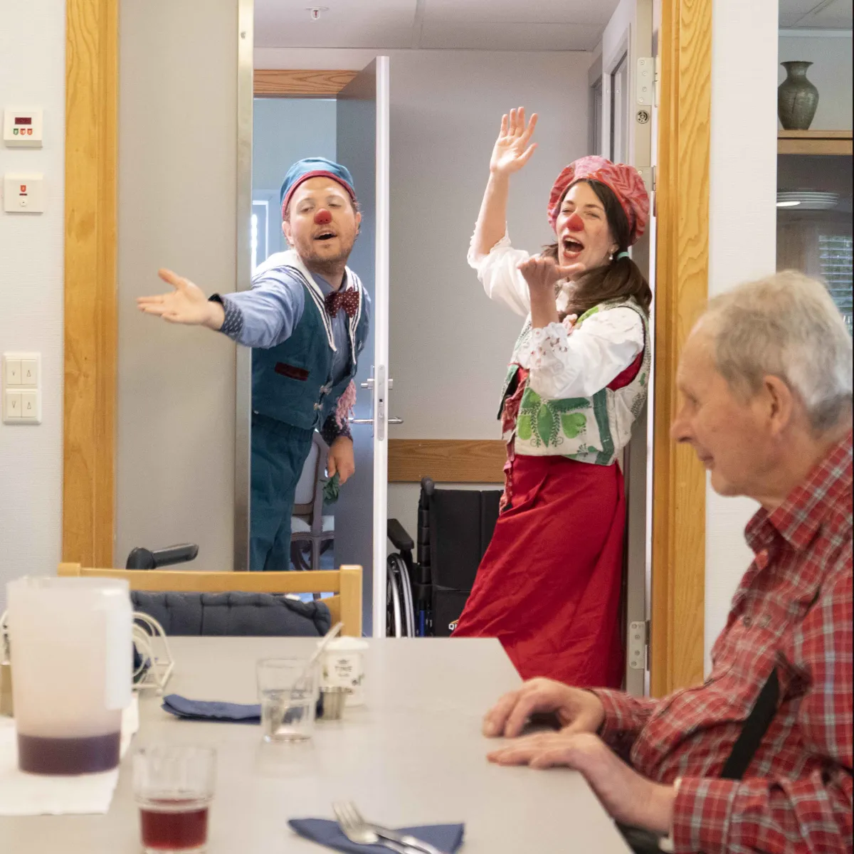 Klokkeklovnene ankommer avdelingen og hilser på en beboer